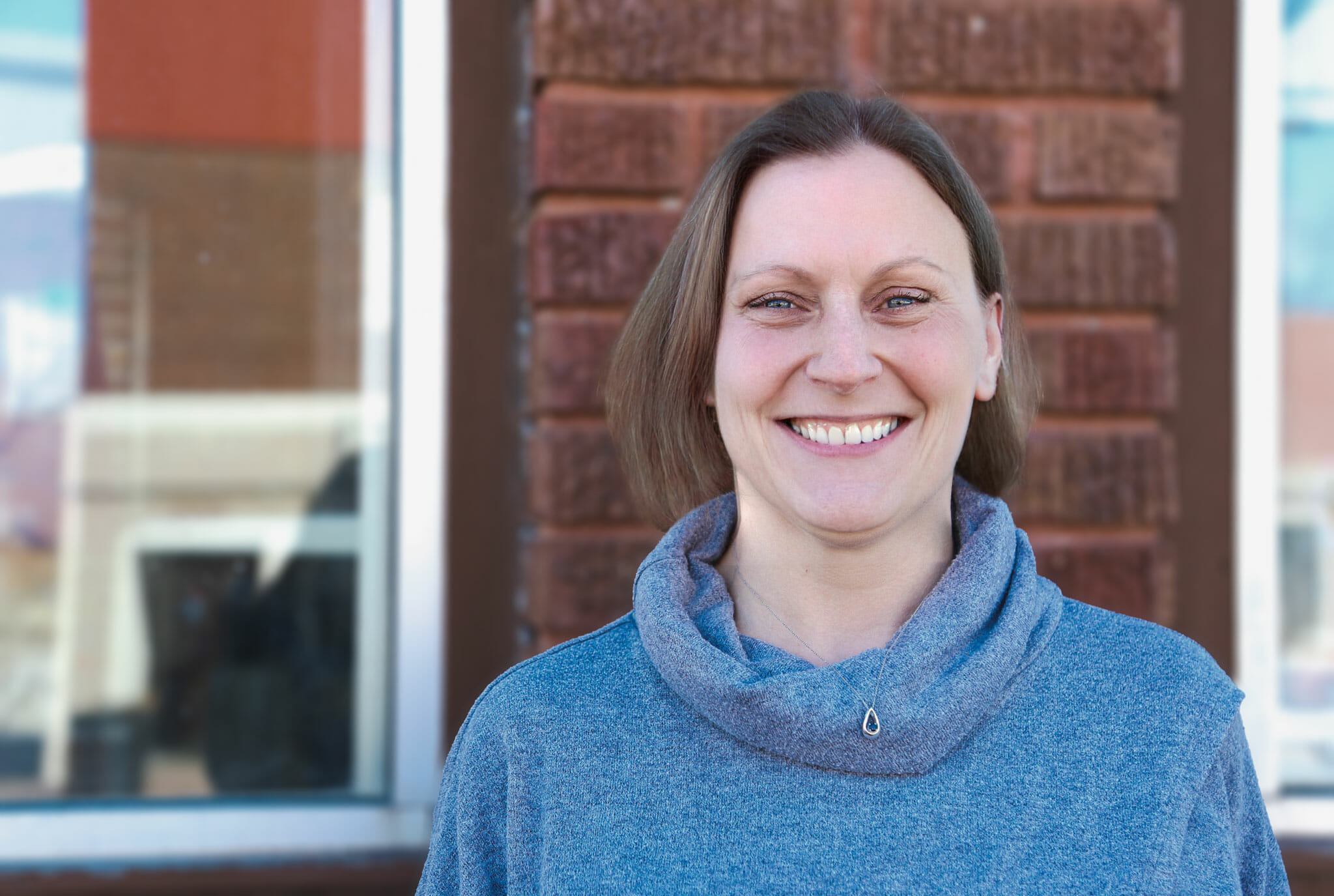 Jen Weiland standing outside Mt. Horeb Pharmacy, smiling