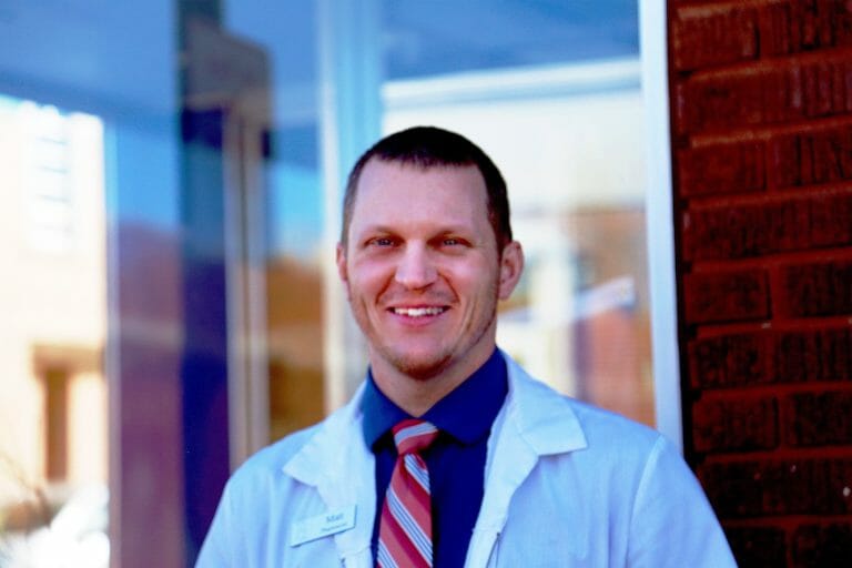 Matt McGowan standing outside Mt. Horeb Pharmacy, smiling