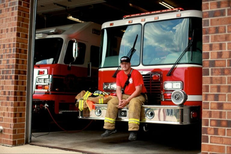 Photo of Brady sitting on the front of a firetruck