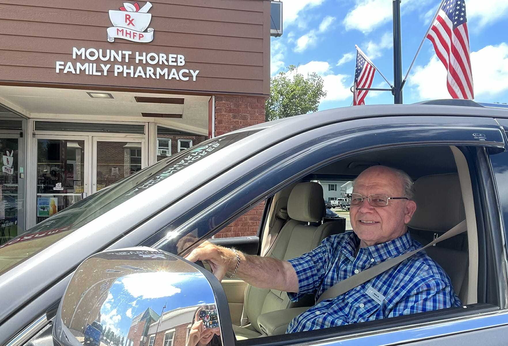 man in vehicle outside pharmacy
